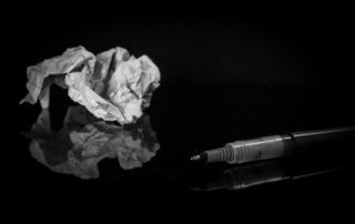crumpled paper and pen