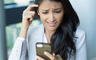 Woman confused by text message or email on phone