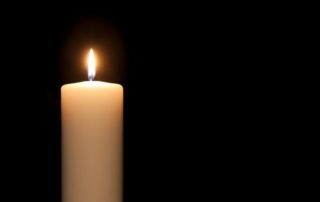 Single candle against dark background