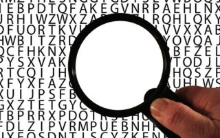 Against a background of letters, the area within a magnifying glass is blank.