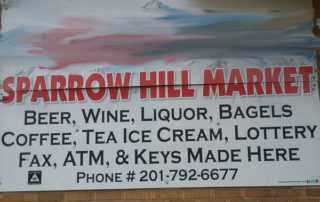 Photo of liquor store sign with a long list of products ending "ATM, & Keys Made Here"