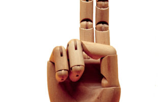 photo of a wooden hand with 2 fingers raised