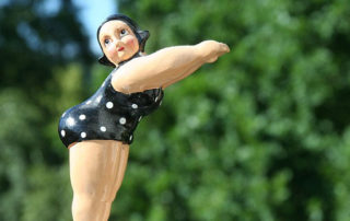 photo of a plastic doll in an old-fashioned bathing suit poised to dive