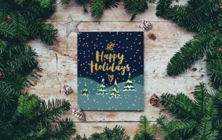photo of holiday card surrounded by evergreen branches